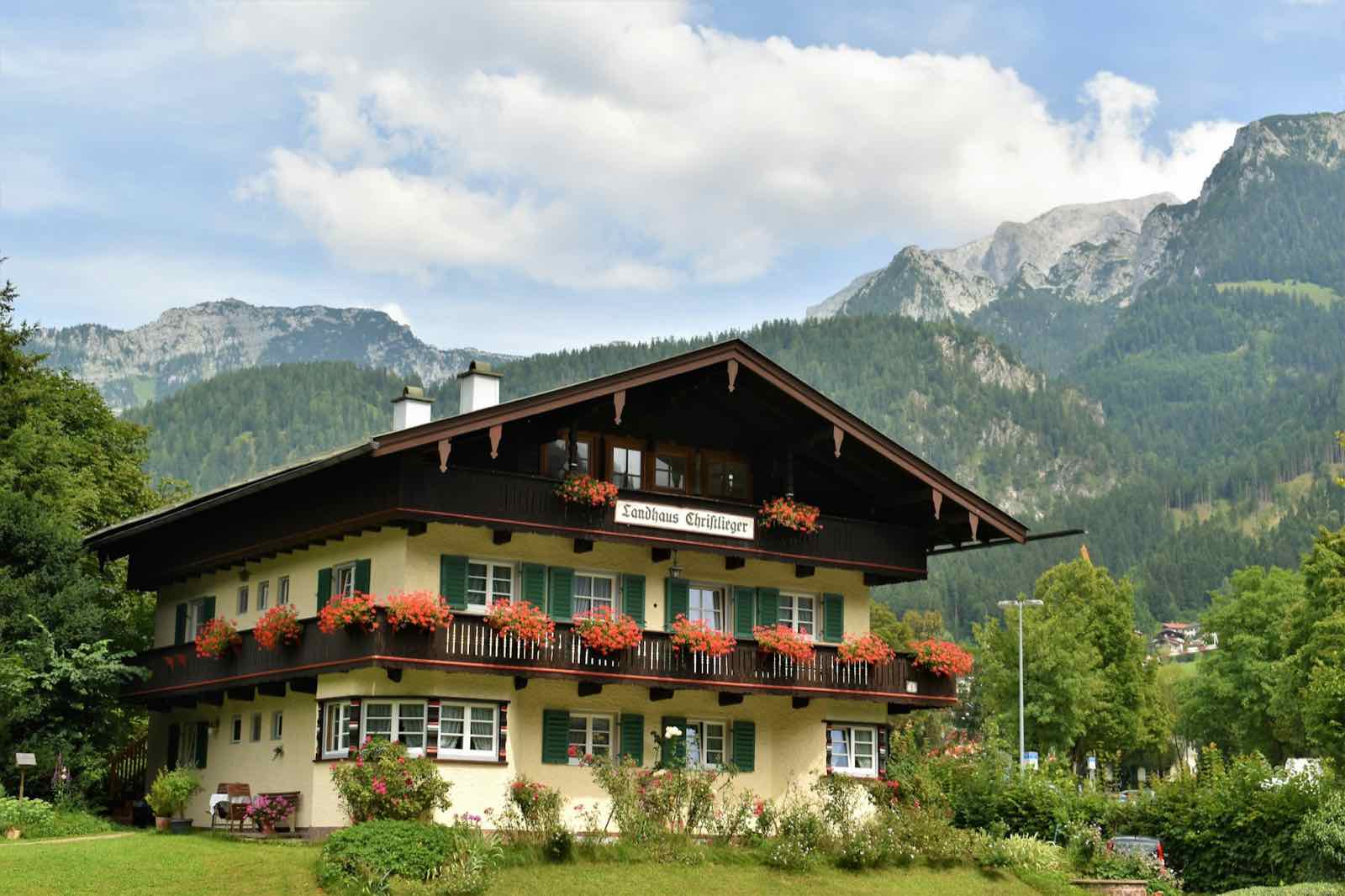Mehrfamilienhaus im alpenländischen Stil vor Bergen